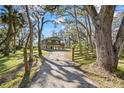 Gravel driveway leads to elevated home nestled amongst trees at 39744 Amber Ave, Zephyrhills, FL 33540