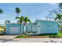 Charming light blue home with attached garage and tropical landscaping at 409 161St Ave, Redington Beach, FL 33708