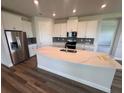 Modern kitchen with stainless steel appliances, a large island, and white cabinets at 4314 Pullet Ct, Lakewood Ranch, FL 34211