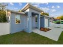 Newly built home with light blue exterior, landscaping, and driveway at 8306 N Marks St, Tampa, FL 33604