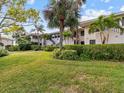 Ground level view of condo building with lush landscaping at 1814 Mariner Dr # 159, Tarpon Springs, FL 34689