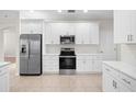 Bright kitchen featuring white cabinets, stainless steel appliances, and ceramic tile flooring at 4104 Warwick Hills Dr, Wesley Chapel, FL 33543
