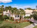 Tan house with palm trees and well-manicured landscaping at 5006 Ruby Flats Dr, Wimauma, FL 33598
