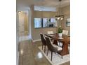 A dining room featuring tile floors, a modern chandelier, and an adjacent kitchen area at 6232 Bayside Key Dr, Tampa, FL 33615