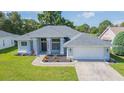 Single-story home with gray roof, attached garage, and a lush green lawn at 10328 Henderson St, Spring Hill, FL 34608