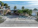 Single-story home with palm trees and brick driveway at 16124 4Th E St, Redington Beach, FL 33708