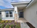 House entrance with stone accents and a dark gray door at 36141 Welsh Glade Rd, Dade City, FL 33525