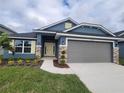 Move-in ready home boasts a two-car garage, attractive exterior, and well-manicured lawn at 36179 Welsh Glade Rd, Dade City, FL 33525