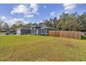 Gray house with a white garage door and fenced backyard at 6103 Fairway Dr, Ridge Manor, FL 33523