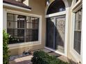 Inviting front entrance with decorative iron security door and landscaping at 9305 Haas Dr, Hudson, FL 34669