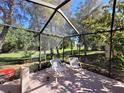 Relaxing screened patio with two chairs and view of backyard at 9305 Haas Dr, Hudson, FL 34669