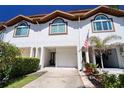 Charming townhouse exterior with a well-maintained lawn, one-car garage, and arched windows for an appealing curb appeal at 273 Madeira Cir, Tierra Verde, FL 33715