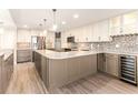 Modern kitchen with a mosaic backsplash, wine cooler, large island, stainless appliances, and pendant lighting at 736 Island Way # 606, Clearwater Beach, FL 33767