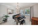Elegant living room featuring a grand piano and chandelier at 9928 Ivory Dr, Ruskin, FL 33573