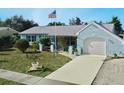 Light blue house with white garage door, American flag, and well-maintained lawn at 2575 Shenandoah St, North Port, FL 34287