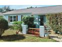 Light blue house exterior with wood accents, lush landscaping, and stone pathway at 2575 Shenandoah St, North Port, FL 34287
