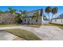 Two-story house with a gray exterior, palm trees, and a spacious driveway at 3953 Arkansas Ave Ne, St Petersburg, FL 33703