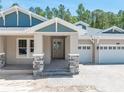 Inviting front entrance with stone accents and a covered porch with direct access to the garage at 5062 Elm Leaf Dr, Brooksville, FL 34601