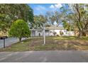 A charming single-story house features a white brick exterior, a carport and a well-kept lawn at 1504 E Mcberry St, Tampa, FL 33610