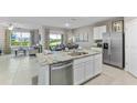 Modern kitchen with granite island, stainless steel appliances, and ample cabinet space at 7210 Beaverhead Ln, Land O Lakes, FL 34638