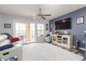 Living room featuring a neutral color scheme, a large TV, and access to a balcony at 9024 White Sage Loop # 37, Lakewood Ranch, FL 34202