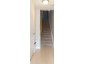 Straight staircase with carpeted steps and tile flooring on the landing at 9024 White Sage Loop # 37, Lakewood Ranch, FL 34202