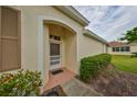 Inviting entryway with a brown door and well-maintained landscaping at 2620 Newcomb Ct, Sun City Center, FL 33573
