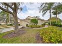 Side view of the house showcasing its attractive facade and lush landscaping at 2620 Newcomb Ct, Sun City Center, FL 33573