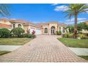 Two-story home with a three-car garage and paver driveway at 8478 Dunham Station Dr, Tampa, FL 33647
