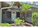 Inviting front entrance with tropical landscaping and a charming white door at 5474 Kemkerry Rd, Wesley Chapel, FL 33543