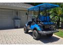 Blue golf cart parked on a brick driveway with garage in the background at 5474 Kemkerry Rd, Wesley Chapel, FL 33543