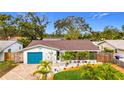 Inviting one-story home with blue garage door and lush landscaping enhancing curb appeal at 5529 11Th N Ave, St Petersburg, FL 33710