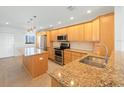 Bright kitchen with light wood cabinets, granite counters, and stainless steel appliances at 8701 Blind Pass Rd # 306B, St Pete Beach, FL 33706