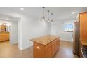 Kitchen with island, light wood cabinets, granite countertops at 8701 Blind Pass Rd # 306B, St Pete Beach, FL 33706