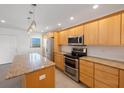 Bright kitchen with island, light wood cabinets, granite counters at 8701 Blind Pass Rd # 306B, St Pete Beach, FL 33706