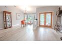 Bright dining area with wood floors, stylish chandelier, and ornate glass paneled doors at 1000 Chillum Ct, Safety Harbor, FL 34695