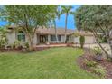 Inviting home with a lush lawn, mature trees, and meticulous landscaping in the front yard at 1000 Chillum Ct, Safety Harbor, FL 34695