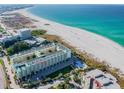 Aerial view of beachfront condo building with pool and parking at 12000 Gulf Blvd # 309N, Treasure Island, FL 33706