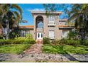 Two-story house with stucco exterior, tile roof, and lush landscaping at 1388 Brightwaters Ne Blvd, St Petersburg, FL 33704