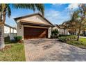 House exterior showcasing a garage and well-maintained landscaping at 16820 Anchor Root St, Wimauma, FL 33598