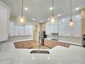 Modern kitchen with white and wood cabinets, and quartz countertops at 295 Woodstream Way, Spring Hill, FL 34608