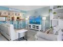 Bright, coastal-style living room with comfortable seating and views into the kitchen at 322 Windrush Blvd # 2, Indian Rocks Beach, FL 33785