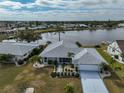 Beautiful waterfront home with well-manicured landscaping and large driveway leading to an attached two-car garage at 407 Blackhawk Cir, Sun City Center, FL 33573