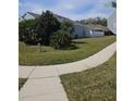 Landscaped side yard with a grassy area and sidewalk at 5125 Silver Charm Ter, Wesley Chapel, FL 33544