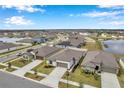Aerial view of a residential neighborhood with houses and a lake at 5493 Blue Azure Dr, Wimauma, FL 33598