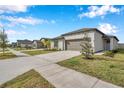 One-story house with attached garage and landscaped lawn at 5493 Blue Azure Dr, Wimauma, FL 33598