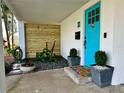Inviting front entrance with a bright turquoise door, a charming welcome mat, and elegant planters in a cozy setting at 5946 Bayou Grande Ne Blvd, St Petersburg, FL 33703