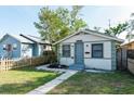 View of single-story home featuring a blue front door, landscaped yard, and a well-maintained lawn at 3424 Queensboro S Ave, St Petersburg, FL 33711