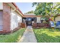Inviting single-story home featuring a charming front entrance with a well-manicured lawn and lush landscaping at 3466 Maclaren Dr, Palm Harbor, FL 34684