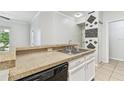 Open concept kitchen with granite countertops, stainless steel sink, and convenient breakfast bar at 5606 Pinnacle Heights Cir # 304, Tampa, FL 33624